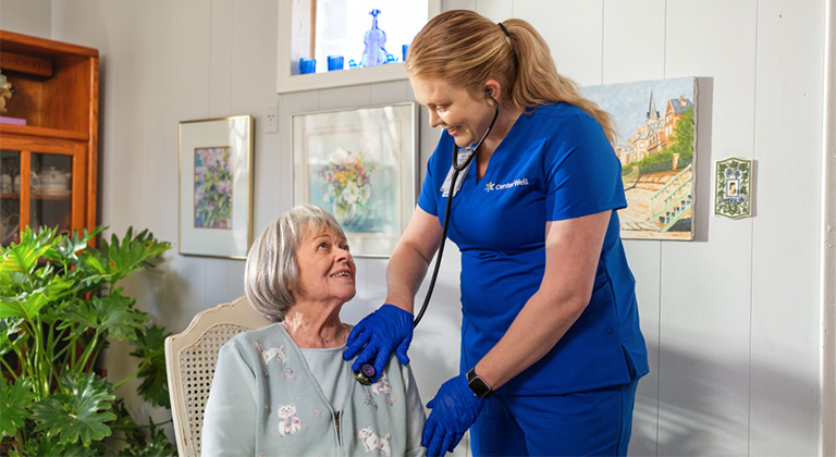 A CenterWell Home Health clinician checking the heart beat of a patient